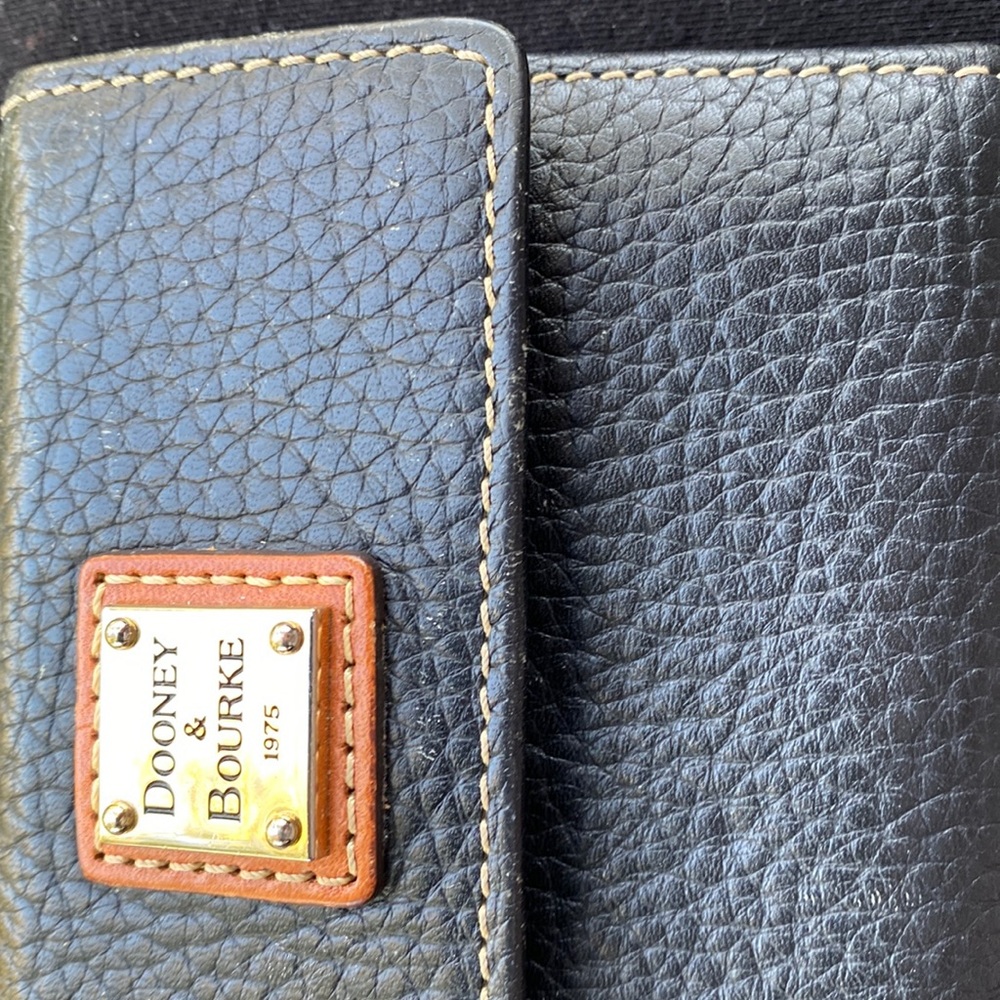 This is a small black Dooney and Bourke wallet that is in very good condition